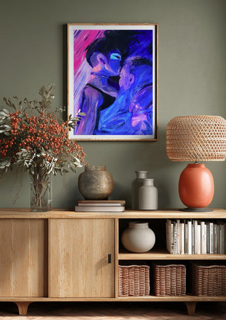 Embrace by Vanyay above a wooden sideboard on a sage green wall