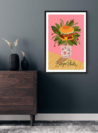 Framed Burger Plante - Nina Broen art print on a gray wall above a wooden dresser with vases.