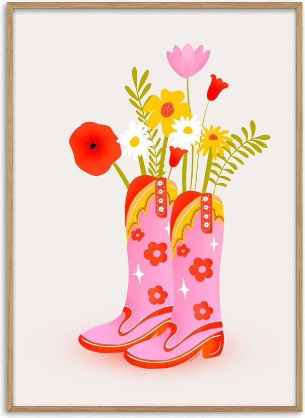 Pink cowgirl boots with yellow trim and floral patterns, filled with colorful blooming flowers.