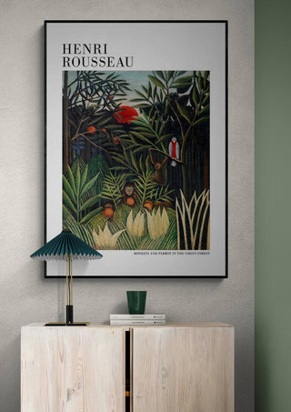 Framed print of Henri Rousseau's "Monkeys And Parrot" displayed above a modern cabinet and lamp.